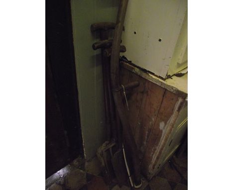 A vintage agricultural scythe with long ashwood handle together with a spade, a shovel and fork, all with T shaped wooden han