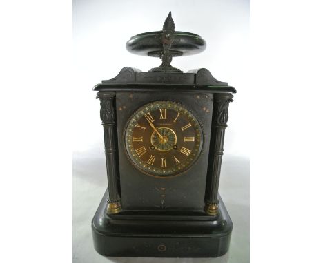 A Victorian black slate mantle clock with cast brass column supports and urn shaped finial with 8 day striking movement retai