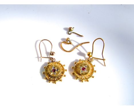 A pair of Victorian style earrings, each suspended with a circular motif with engraved border, centred with an untested ruby 