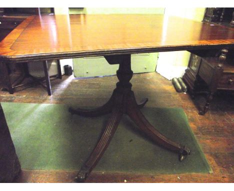 A Regency mahogany breakfast table, of square cut form with wide banded borders, raised on a vased shaped pillar and reeded q