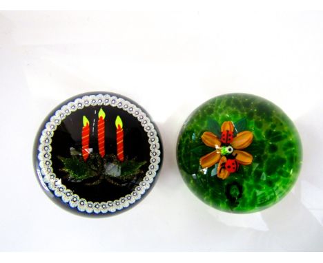 A Scottish glass Millefiori paperweight by William Mountson detailing three lit candles beneath holly sprigs, set upon a dark