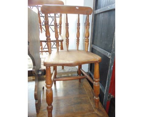 A pair of Windsor elm and beechwood kitchen chairs with turned spindle backs over saddle shaped seats, further turned support