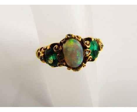 A Victorian style opal, emerald and diamond ring, centred with an oval cabochon opal, flanked to each shoulder with an oval m