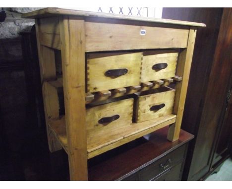 A rustic stripped pine kitchen work table of rectangular form raised on four rectangular cut supports united by an under tier