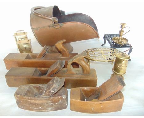 An antique copper coal scuttle filled with various old timber carpentry planes, a pierced brass trivet, a further iron exampl
