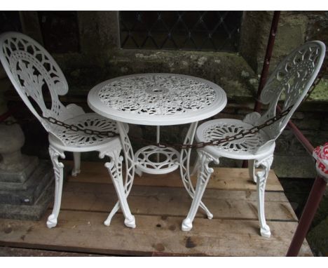 A Victorian style cast aluminium three piece garden terrace set comprising circular topped table with decorative pierced and 