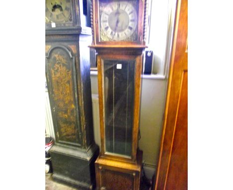 An Edwardian oak longcase clock, the square brass dial with applied spandrels and silvered chapter ring, the hood with spiral