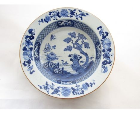 A late 18th century oriental basin, of shallow form, with blue and white painted decoration of a goose swimming on a lake bes