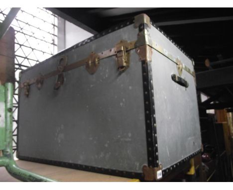 A large cabin trunk of rectangular form with re-inforced detail together with two vintage tin trunks housed within