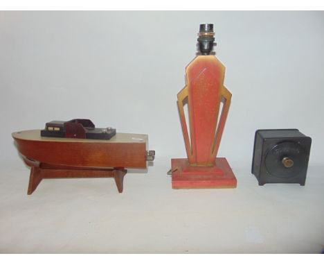 A good quality novelty cigarette dispenser in the form of a speedboat with a timber base and applied Bakelite detail, togethe