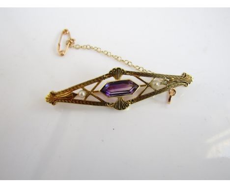 A gem-set brooch, of shaped kite form, centred with an untested amethyst, flanked to each side with a pearl, in 14ct gold
