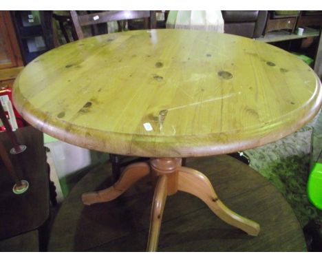 A modern stripped breakfast table of circular form raised on a central vase shaped pillar and four shaped and moulded legs to