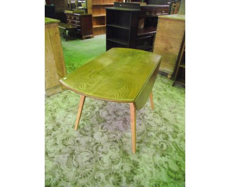 An Ercol medium to light elm and beechwood oval drop leaf dining table raised on four splayed square tapered legs to seat fou