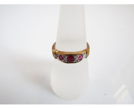 A ruby and diamond ring, centred with an oval mixed-cut untested ruby, flanked to each side with a round mixed-cut untested r