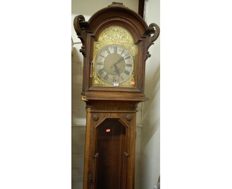 A circa 1900 Continental geometric moulded oak longcase clock, having an arched brass and silvered dial, glazed trunk door, w