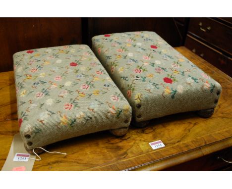 A pair of floral tapestry upholstered rectangular low footstools, each on bun supports, w.40cm