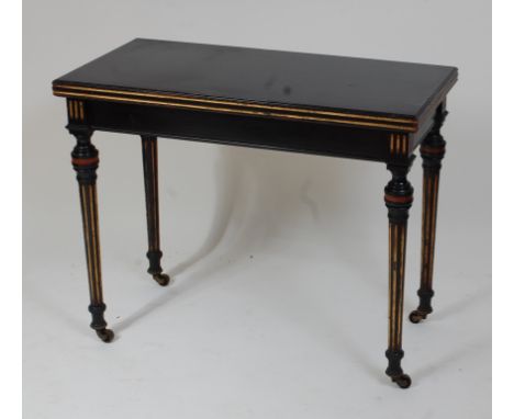 A Victorian ebonised and parcel gilt card table, the fold-over top having a moulded edge, opening to reveal baize lined playi