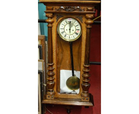 A late 19th century figured walnut Vienna drop trunk wall clock, having central white enamel dial, twin winding holes for a w
