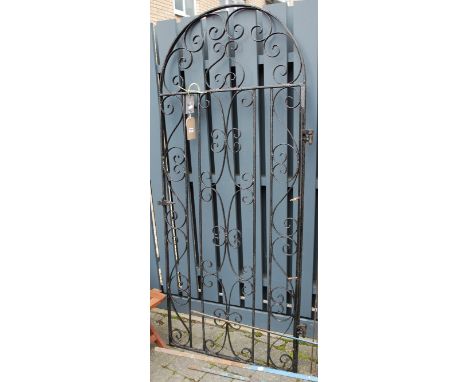A black painted wrought iron arched single garden gate, with hinged attachement; together with three metal ornate garden scre