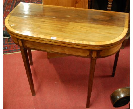 An early 19th century mahogany and satinwood crossbanded, further ebony strung D-shaped fold-over baize lined card table, hav