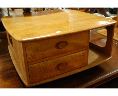 An Ercol blond elm Pandora's Box coffee table, having twin drawers with further open compartments, on roller castors, w.80cm