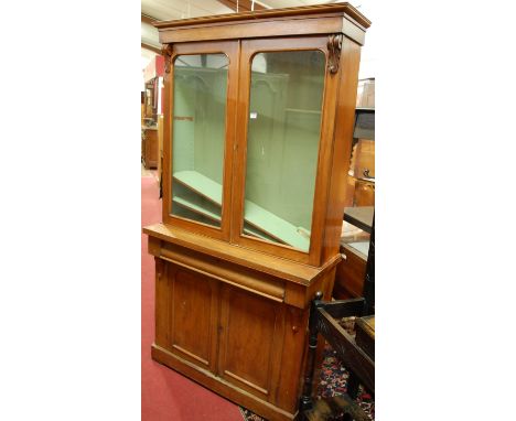 A mid-Victorian mahogany bookcase cupboard, the twin arch glazed upper doors over base fitted with cushion frieze drawer to f