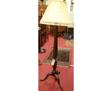 An early 20th century relief carved mahogany pedestal standard lamp, having part reeded column