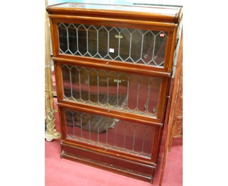 A 1920s Globe Wernicke mahogany three tier stacking bookcase, each tier having lead glazed hinged door, w.86.5cm