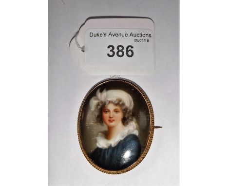 A CONTINENTAL PAINTED PORCELAIN OVAL PLAQUE decorated with a portrait of a boy, contained in a yellow metal brooch mount, 5.2