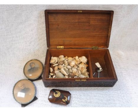 AN INDIAN CARVED AND BRASS INLAID BOX containing seashells, Edwardian photograph frames and a cigarette case