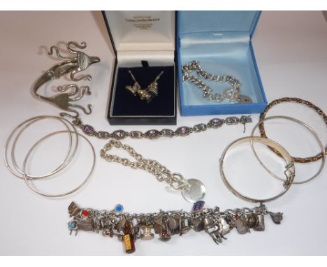 A WHITE METAL AND SILVER CHARM BRACELET and other costume jewellery including a silver bangle with engraved decoration