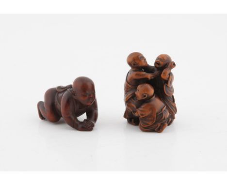Two Japanese Wooden Netsuke , Meiji period including a katabori netsuke of a carved baby boy crawling, wearing apron-like gar