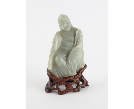 A Chinese Jade Sculpture of a Luohan 19th century or later the Luohan is seated on a wooden throne style stand 11.5 cm high 