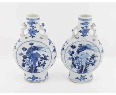 A Pair of Chinese Blue and White Moon flasks, 19th Century.  Painted on a crackle glaze with flowers and peacocks .  Some  pi