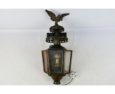 A late 19th or early 20th century copper and brass lantern of hexagonal section, with eagle surmount, converted, approximatel