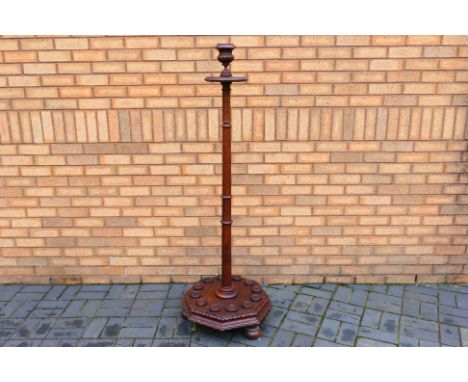 A late Victorian mahogany billiards or snooker cue stand for twelve cues, the turned column rising from an octagonal plinth b