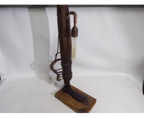 A period Shoe Last converted in the form of a table lamp, the lamp stem of period oak, mounted on a rectangular wooden base, 
