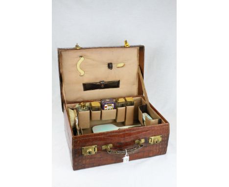 Mid 20th century Crocodile Skin Travelling Case, the interior fitted with Four Glass Jars with Silver Gilt Lids (London 1948)