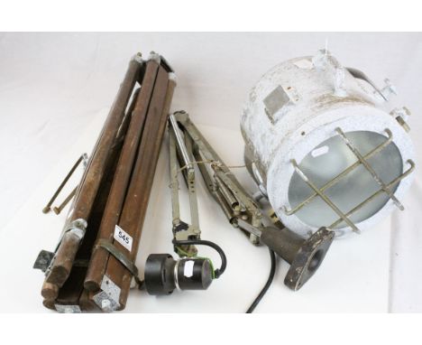 A vintage spotlight and tripod stand together with a Herbert Terry lamp