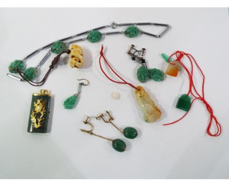 A collection of jade and hardstone carved jewellery to include a pendant set with opal, other pendants and similar