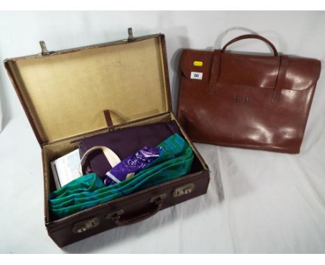 A good quality vintage leather satchel containing piano tutorial books and a vintage leather suitcase containing material