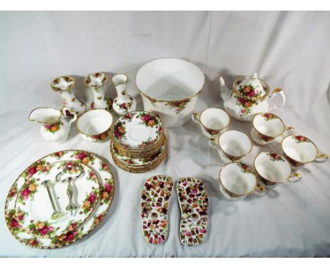 A good quantity of Royal Albert Old Country Roses to include a cake stand, teapot, a pair of candlesticks, a planter, saucers