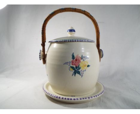 Poole Pottery - a lidded biscuit barrel with swing handle, shape no 230, 16 cm (h) and underplate - Est £20 - £30 