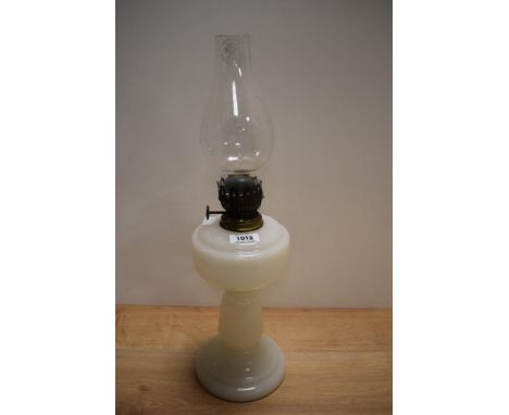 A vintage milk glass oil lamp with chimney.