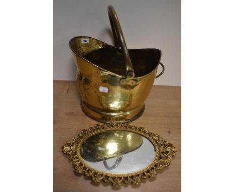 A vintage brass coal helmet and a castcraft cast metal mirror, having gold tone finish.