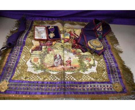 A Manchester Unity of Oddfellows fraternal sash and associated medallion and an apron of similar design with intricate embroi