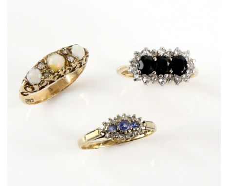 Three gem set rings, one set with sapphires and diamonds, another  with sapphire and paste and a vintage opal dress ring, all