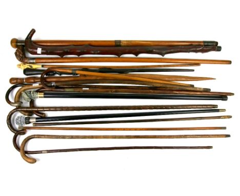 Twenty-two walking sticks/riding crops/whips to include carved wood dogs head, tripod and another with a carved ivory figural
