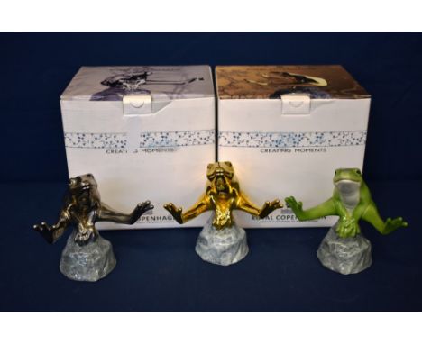 Three Royal Copenhagen porcelain good luck frogsby sculptor Allan Therkelsen, modelled jumping over stones, one no. 556 in gr