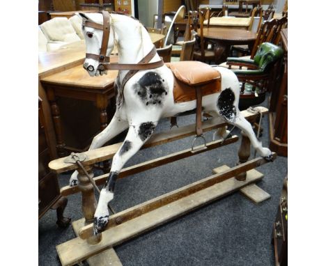 EARLY 20TH CENTURY DAPPLE ROCKING HORSE, leather mane, later saddle on trestle base, 143cms longThe horse is missing a lot of
